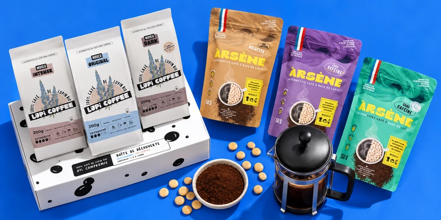 Boîte de découverte Lupi Coffee et sachets Arsène posés à côté d’une cafetière à piston et d’une coupelle de mouture