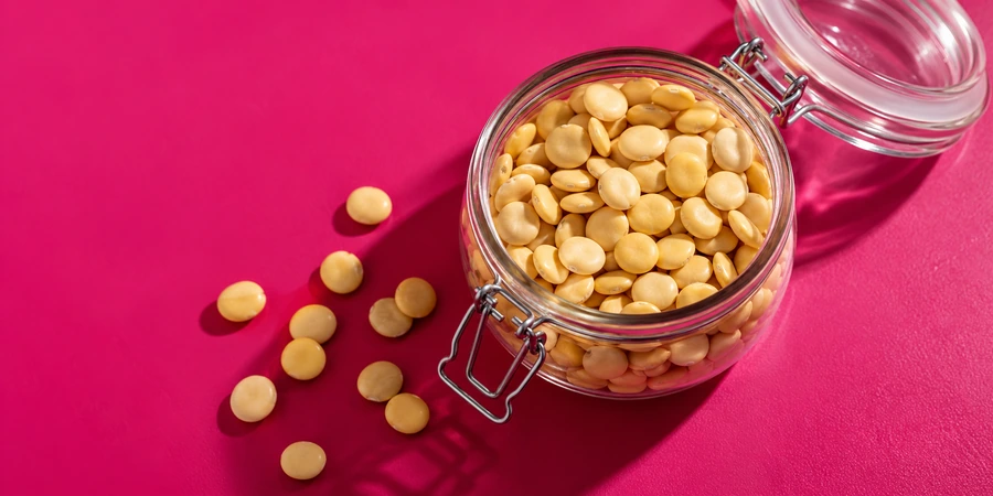 Graines de lupin sèches de couleur crème dans un bocal en verre ouvert